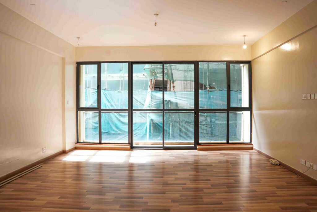 Empty bedroom with full-width sliding glass doors and timber flooring at 5th Park Heights