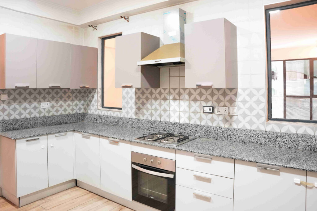 Fitted kitchen with granite worktops and patterned tile splashback at 5th Park Heights