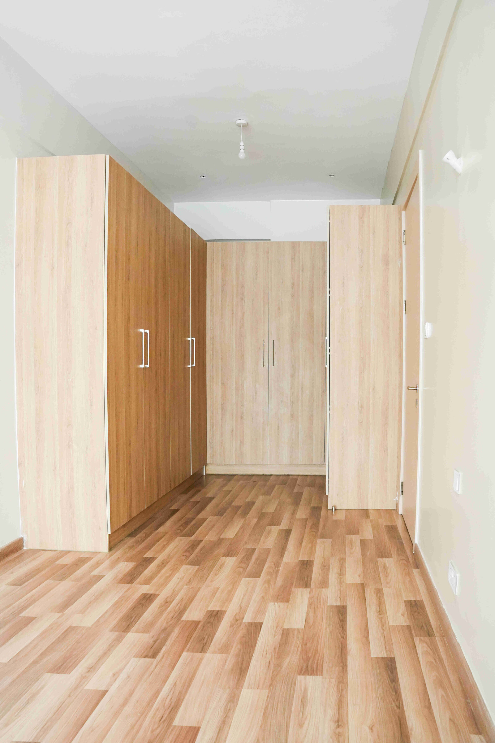 Full-height fitted wardrobes in light oak with timber flooring at 5th Park Heights
