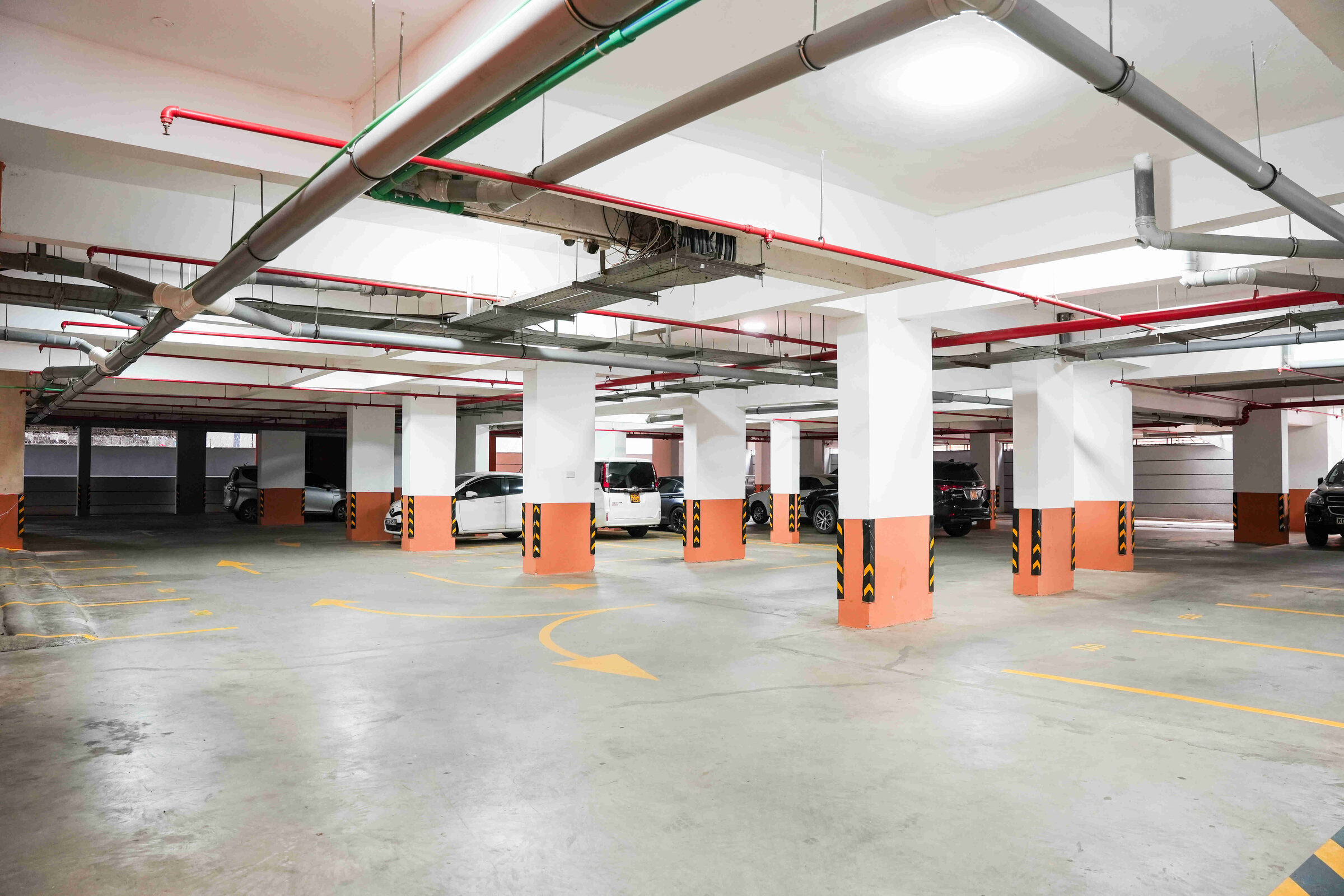 Basement car park with marked bays and fire suppression pipework at 5th Park Heights