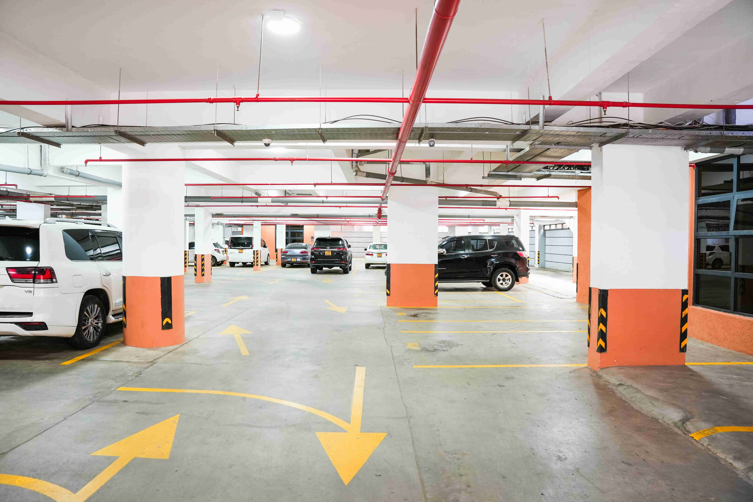Occupied basement car park with yellow directional markings at 5th Park Heights
