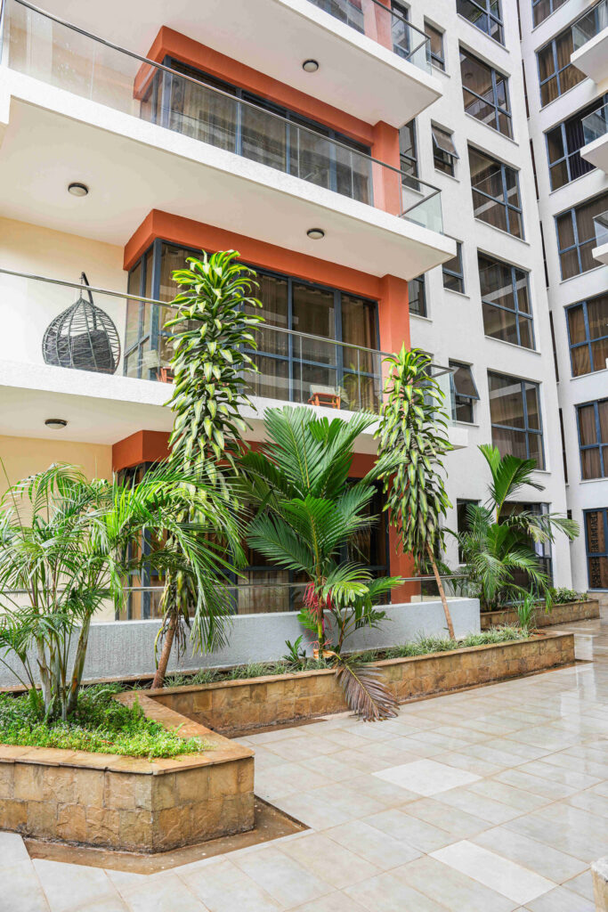 Courtyard garden with tropical planting and building balconies at 5th Park Heights