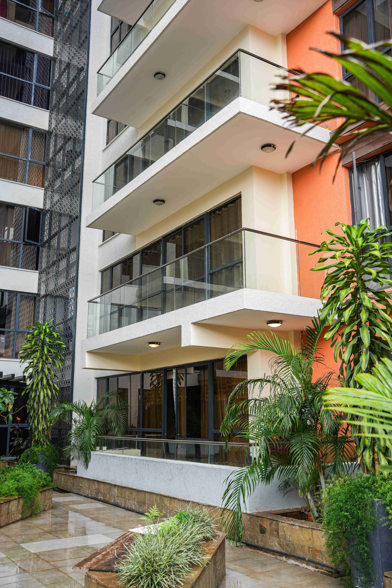 Stacked balconies with glass balustrades above the courtyard garden at 5th Park Heights